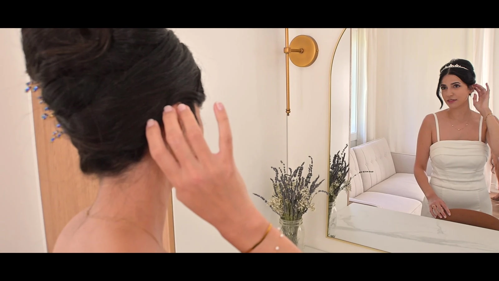 Jodie adjusting her hair in a mirror before the wedding