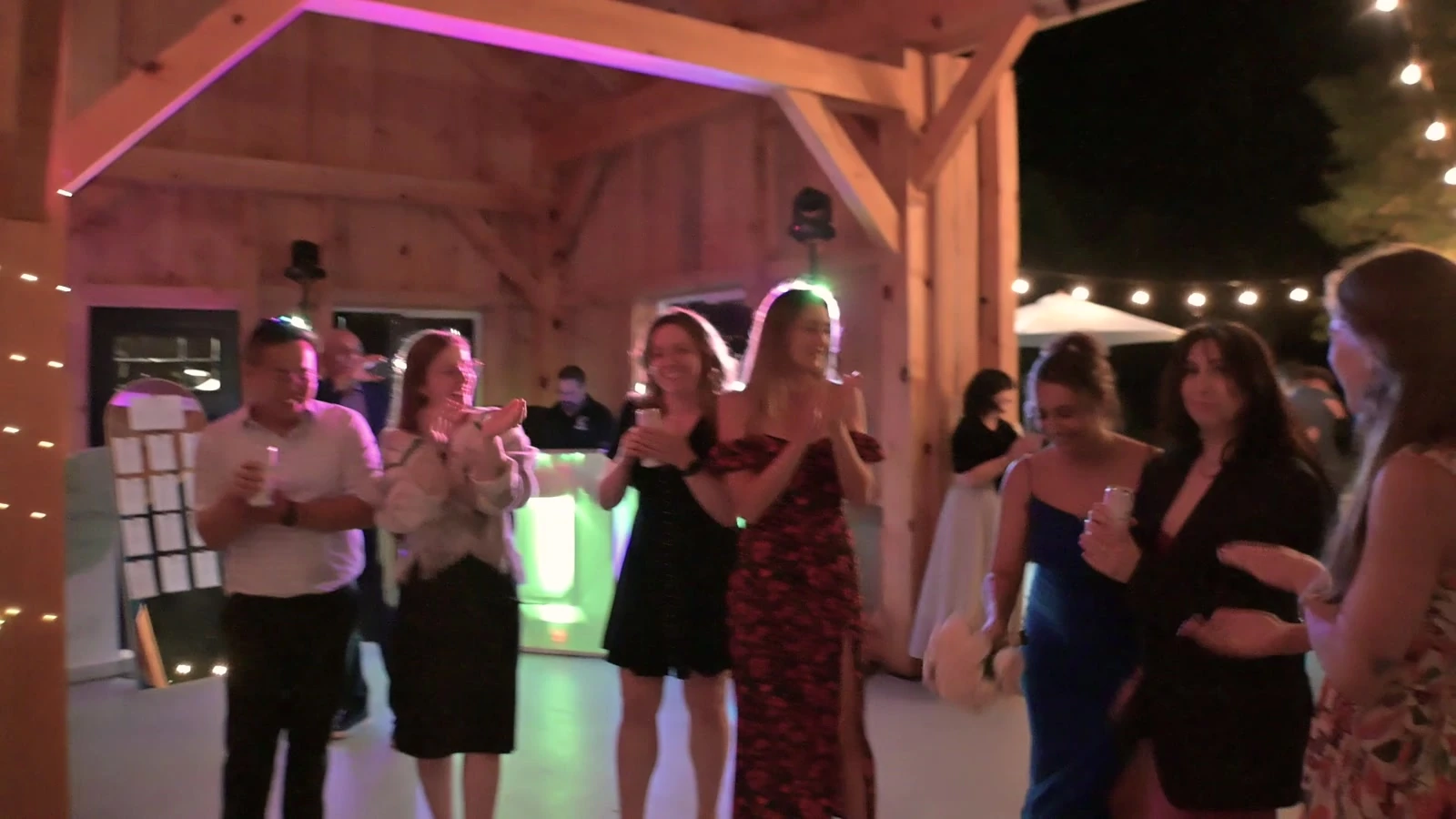 Guests dancing at the reception under coloured lighting