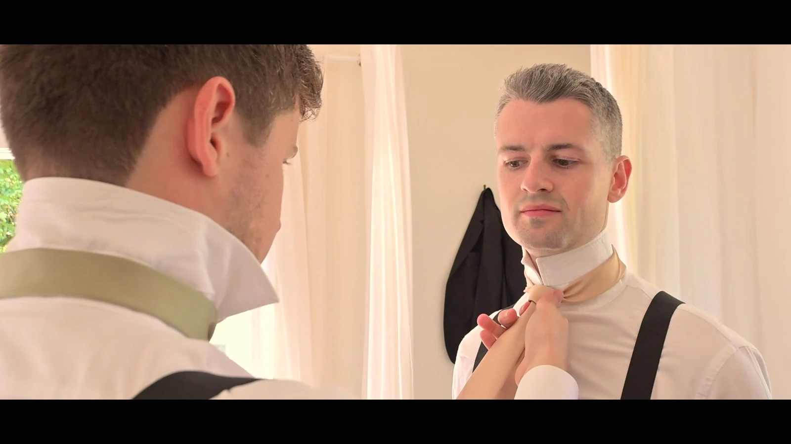 Kevin adjusting his tie in a mirror