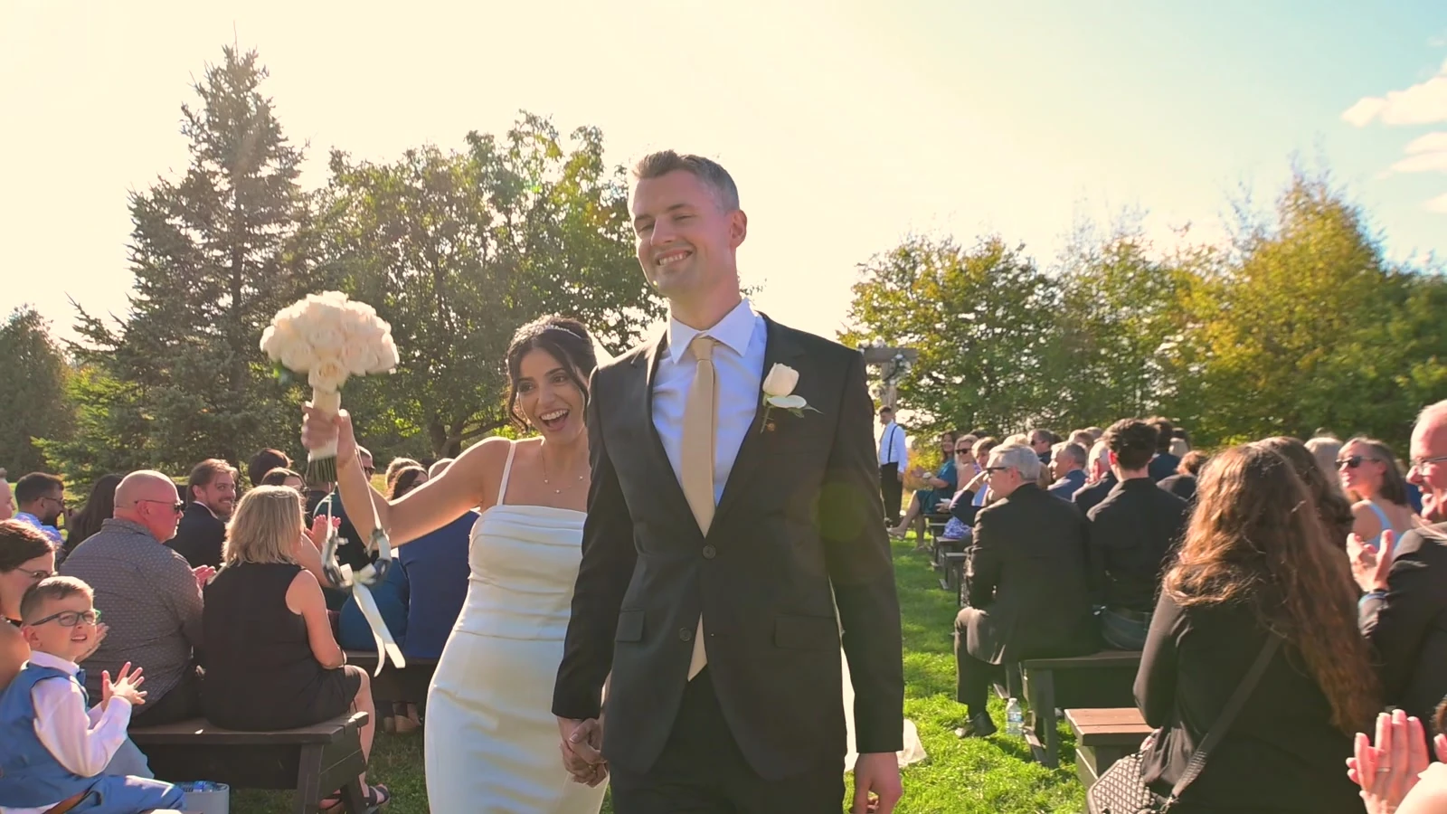 Kevin and Jodie walking between applauding wedding guests